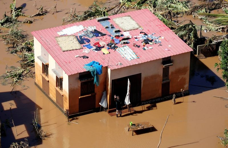 Homem acena perto da sua casa inundada após a passagem do Ciclone Idai no distrito de Buzi, perto de Beira, em Moçambique — Foto: Reuters/Siphiwe Sibeko