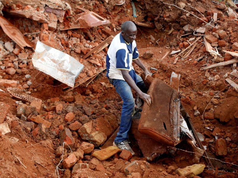 Homem procura por documentos em meio a escombros após passagem de ciclone no Zimbábue — Foto: REUTERS/Philimon Bulawayo