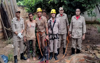 Vítima ao lado dos bombeiros e da cisterna de onde foi resgatada — Foto: Divulgação/Corpo de Bombeiro